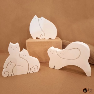 Tre diversi modelli di gatti innamorati in gesso bianco.