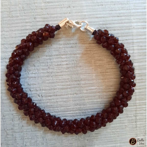 Braccialetto Kumihimo amaranto scuro di perline in vetro sfaccettato con chiusura argentata.