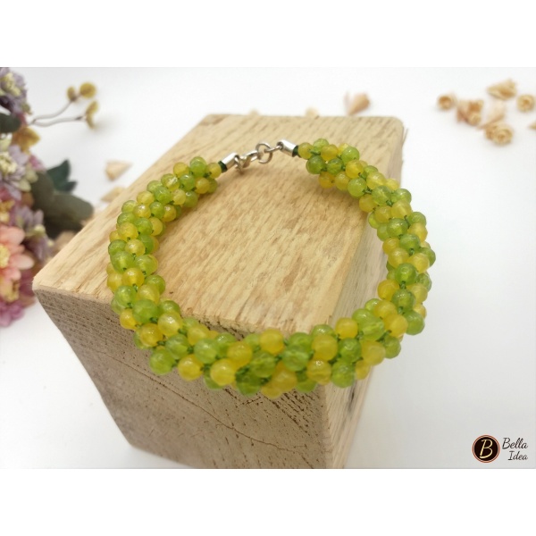 Bracciale con perline di agata gialle e verdi su blocco di legno