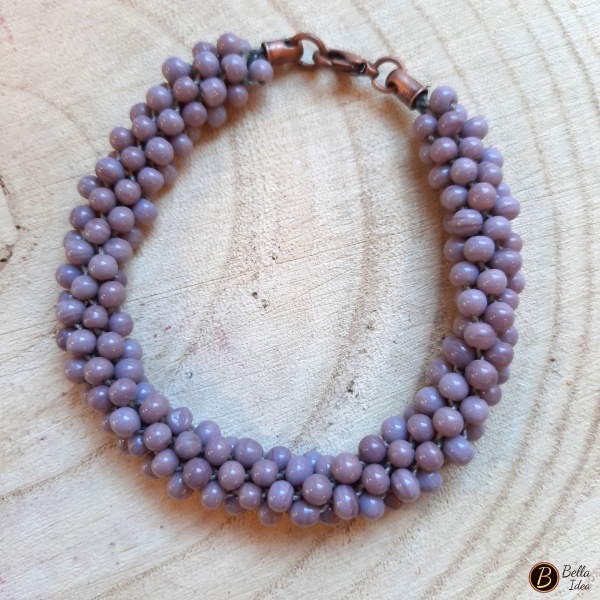 Braccialetto Kumihimo in perline color glicine di vetro lumè con chiusura ramata.