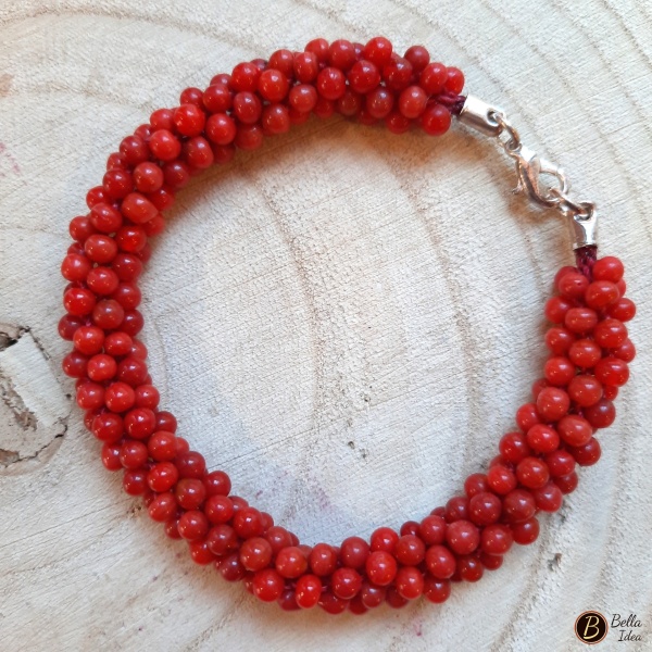 Braccialetto Kumihimo in perline rosse di vetro lumè  con chiusura argentata.