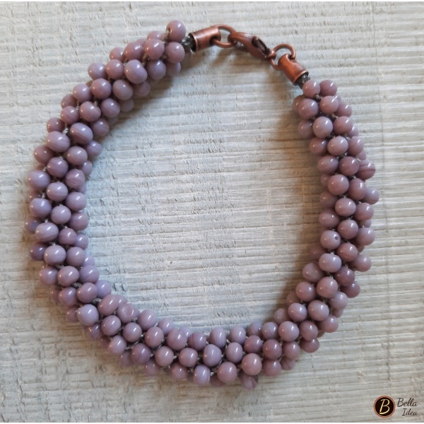 Braccialetto Kumihimo in perline lumè color glicine con chiusura in metallo ramato.