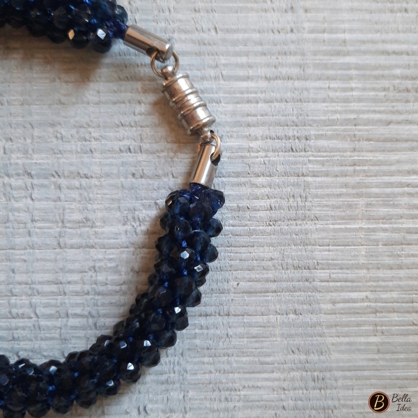 Dettaglio di braccialetto Kumihimo in perline blue navy in vetro sfaccettato con chiusura a calamita