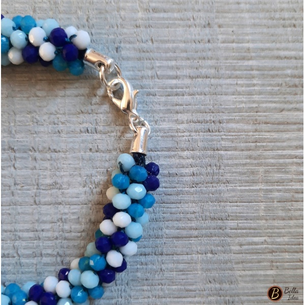 Dettaglio di braccialetto Kumihimo in perline mix blue vetro sfaccettato con chiusura argentata