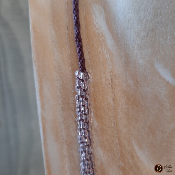 Dettaglio di collana Kumihimo in perline di mezzo cristallo color ametista con chiusura a moschettone argentato.