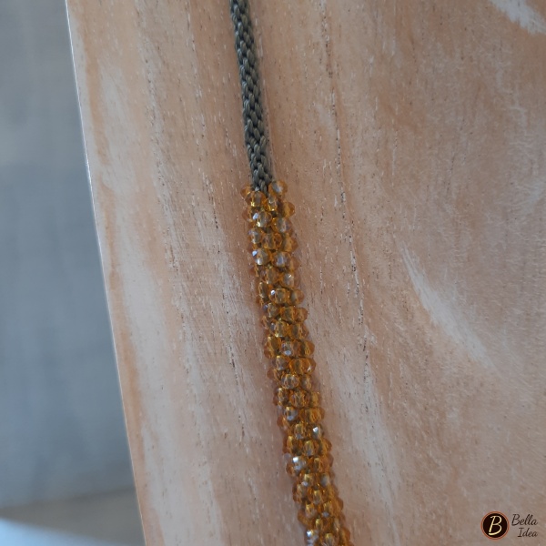 Dettaglio di collana Kumihimo in perline di mezzo cristallo giallo oro con chiusura dorata.