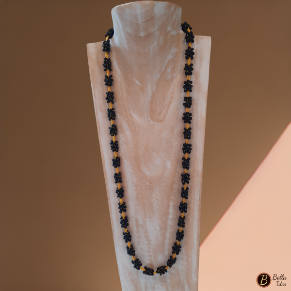 Collana Kumihimo in perline tonde nere intercalata a filo giallo con chiusura dorata.