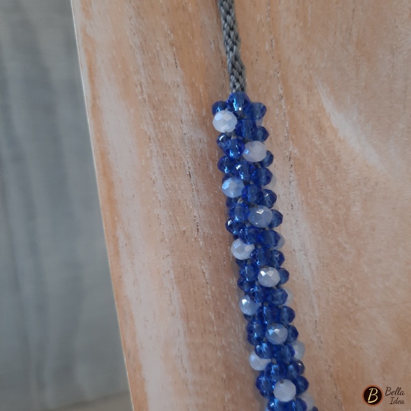 Dettaglio di collana Kumihimo in perline di vetro sfaccettato blue e celeste con chiusura argentata