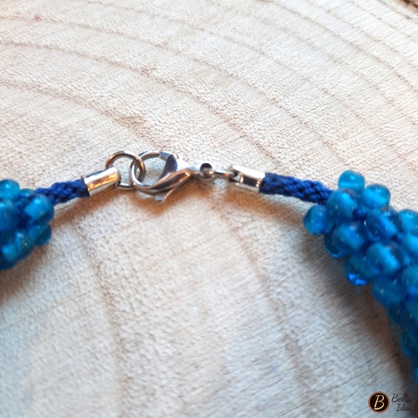 Dettaglio di braccialetto Kumihimo in perline blue di vetro lumè  con chiusura in acciaio.
