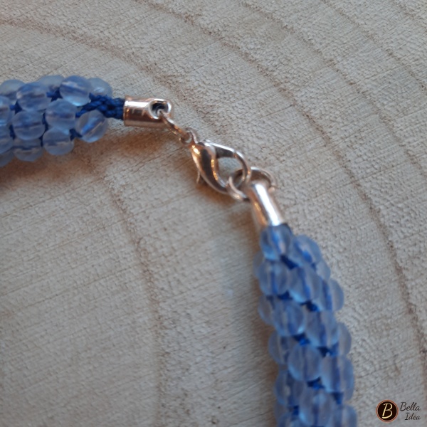 Dettaglio di braccialetto Kumihimo in perline celeste di mezzo cristallo con chiusura argentata