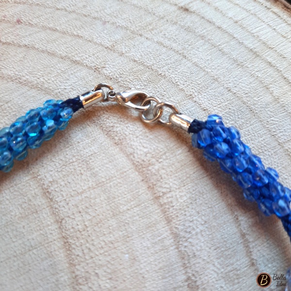 Dettaglio di braccialetto Kumihimo in perline in tre tonalità di azzurro mezzo cristallo.