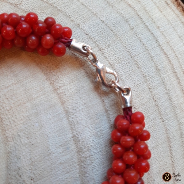 Dettaglio di braccialetto Kumihimo in perline rosse di vetro lumè  con chiusura argentata.
