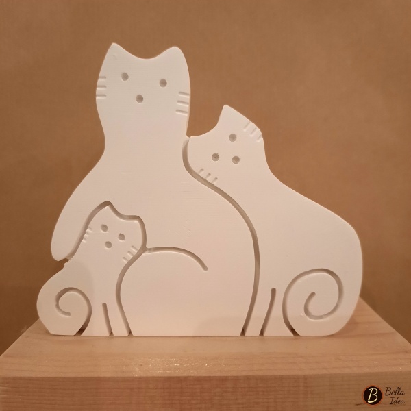 Gatti in gesso bianco che rappresentano una famiglia.