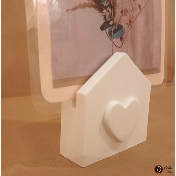 Dettaglio di portafoto in gesso bianco a forma di bustina con cuore in rilievo