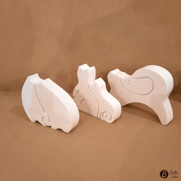 Tre diversi modelli di gatti innamorati in gesso bianco visione laterale.