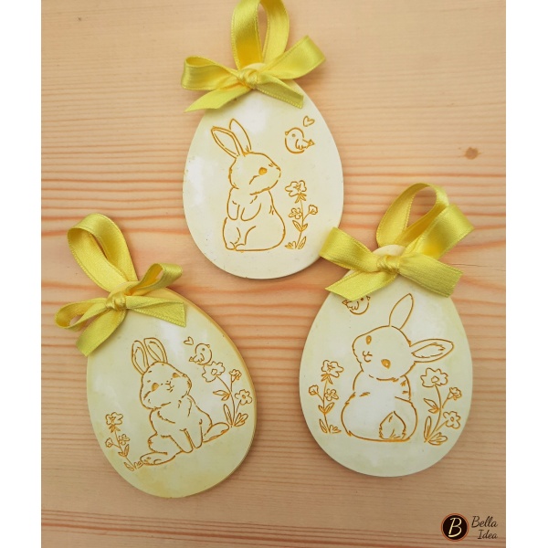 Tre uova in gesso  giallo da appendere con disegni di coniglietti